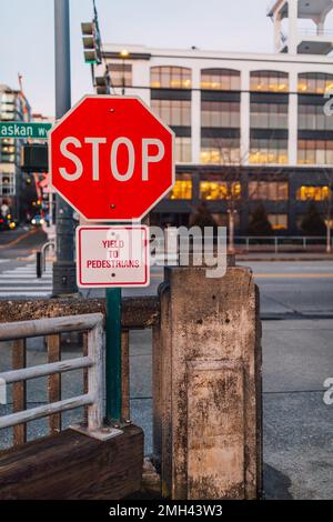 Stoppschild auf dem Alaskan Way in Seattle mit Schild „Field to pedestrians“ am Pier 70 an der Uferpromenade Stockfoto