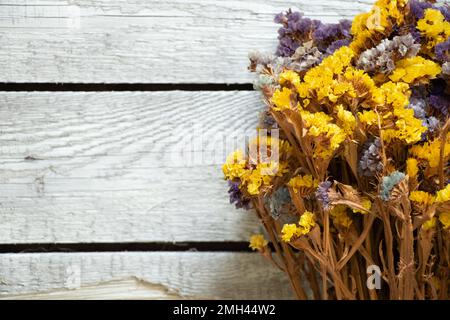 Blumen Limonium sinuatum auf Holzhintergrund, Blumenhintergrund, getrocknete Blumen Stockfoto