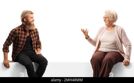 Ein junger Mann mit Bart sitzt auf einem weißen Brett und spricht mit einer älteren Frau, isoliert auf weißem Hintergrund Stockfoto