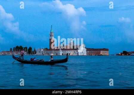 Eine Gondel fährt vor der Basilika San Giorgio Maggiore an der Lagune von Venedig vorbei Stockfoto