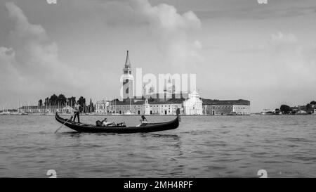 Eine Gondel fährt vor der Basilika San Giorgio Maggiore an der Lagune von Venedig vorbei Stockfoto