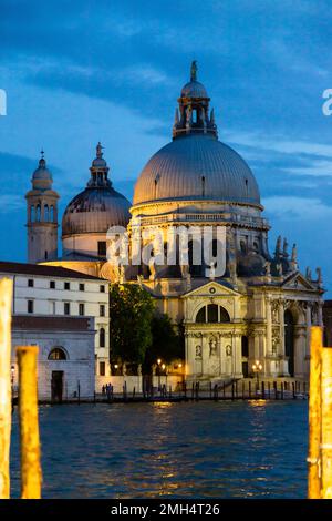 Am frühen Abend in Venedig, beleuchtete Gebäude und Touristen, die diese wunderschöne Stadt genießen Stockfoto