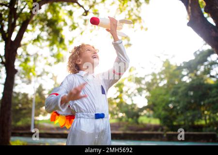 Kleiner Junge, der mit dem Raumschiff spielt. Astronaut Kostüm für Halloween Party. Kreatives Kind mit Weltraumrakete. Kinder träumen und stellen sich vor. Stockfoto