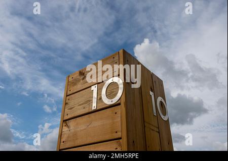 Die Nummer zehn aus Edelstahl auf einem Holzhintergrund am Himmel. 10 Stockfoto