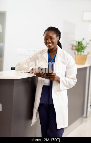 Portrait einer glücklichen afroamerikanischen Ärztin, die im Krankenhaus arbeitet, die Tablette hält Stockfoto