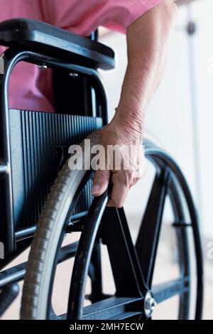 Nahaufnahme einer leitenden weissen Patientin im Rollstuhl im Krankenhaus Stockfoto