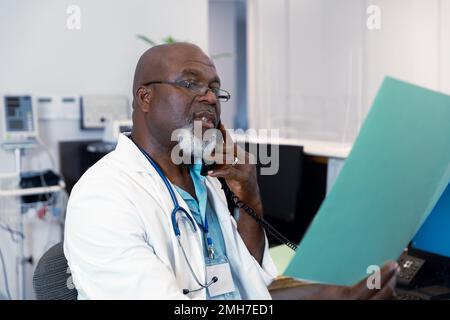 afroamerikanischer Arzt, der im Krankenhaus arbeitet, telefoniert Stockfoto