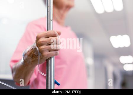 Nahaufnahme einer leitenden weissen Patientin mit Tropf im Krankenhausgang Stockfoto