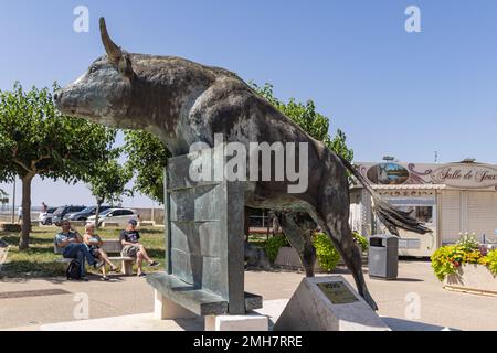 Saintes-Maries-de-la-Mer, Bouches-du-Rhône, Provence-Alpes-Cote d'Azur, Frankreich. 3. Juli 2022. Bronzestatue eines Bullen, der einen Zaun in Saintes-Marie springt Stockfoto