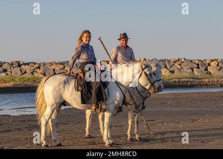 Saintes-Maries-de-la-Mer, Bouches-du-Rhone, Provence-Alpes-Cote d'Azur, Frankreich. 5. Juli 2022. Mann und Frau reiten in der Camargue. Stockfoto