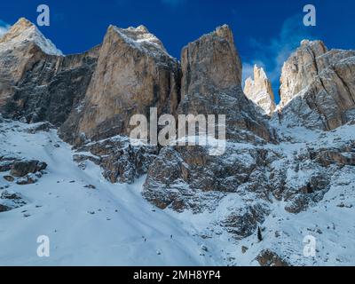 Winzige Wanderer auf einem Winterpfad in Richtung Vajolet Refuge ab Vigo di Fassa, Dolomiten, Italien Stockfoto