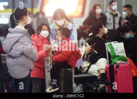 HANGZHOU, CHINA - 27. JANUAR 2023 - Junge Passagiere und ihre Eltern warten auf einen Hochgeschwindigkeitszug am Ostbahnhof Hangzhou in Hangzhou, Osten Stockfoto