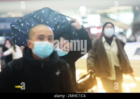 HANGZHOU, CHINA - 27. JANUAR 2023 - Passagiere tragen ihr Gepäck beim Betreten der Warterhalle des Ostbahnhofs Hangzhou in Hangzhou, Osten Stockfoto