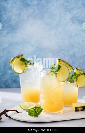 Mai Tai-Cocktail in verschiedenen Gläsern garniert mit Ananas und Limette Stockfoto