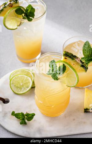 Mai Tai-Cocktail in verschiedenen Gläsern garniert mit Ananas und Limette Stockfoto