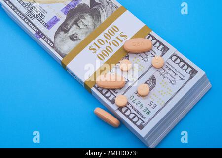 Opioid-Krisen-Medikamente Pillen verschreibungspflichtige Medikamente und Geld hellblauer Hintergrund Hunderte von Dollar Stockfoto