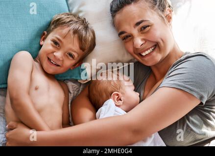 Mein Leben ist komplett mit meinen Jungs darin. Eine junge Frau, die sich mit ihren beiden Söhnen zu Hause anfreundet. Stockfoto