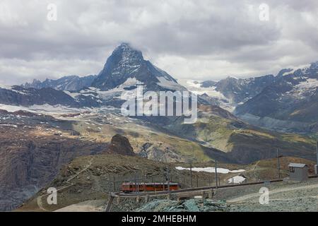 Roter Zug auf dem Hintergrund des Matterhorns in den Schweizer Alpen Stockfoto