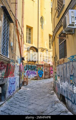 Eine kleine, kurvige Gasse im Viertel Centro Historico, mit bedeckten Mauern. Ein Beispiel für Graffiti in Neapel, Neapel, Italien, Italien. Stockfoto