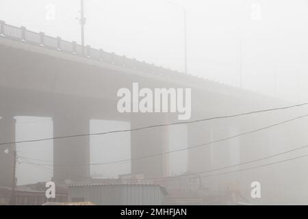 Garagen für Boote im Nebel unter einer Brücke am dnieper River am Morgen im Herbst Stockfoto