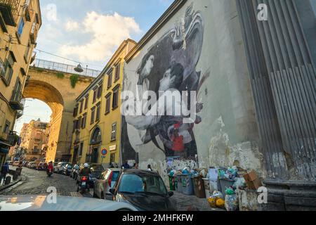 Ein großes Wandgemälde an der Seite der katholischen Kirche, Basilika di Santa Maria della Sanità. Es zeigt einen Jungen, der mit einer Krankheit zu tun hat. Ein Beispiel für Graffi Stockfoto