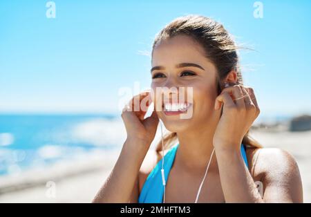 Musik hilft mir wirklich, loszulegen. Eine sportliche junge Frau, die beim Workout Musik hört. Stockfoto