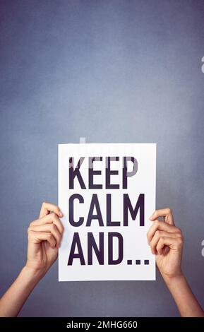 Wie das alte Sprichwort schon sagt... eine nicht identifizierbare junge Frau, die ein Poster mit einer Nachricht im Studio hält. Stockfoto