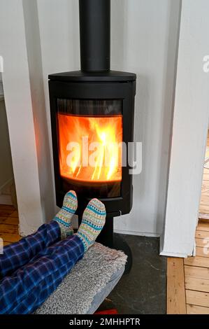 Ein Mann im Schlafanzug, der vor dem gusseisernen Stein sitzt Stockfoto