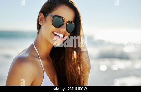 Sonnenbrillen sind kleine Kunstwerke. Nahaufnahme einer schönen jungen Frau, die einige Zeit am Strand verbringt. Stockfoto