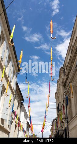 Farbenfrohe Sonnenschirme in der Stadtstraße in westfranzösischer Stadt jonzac geschlossen Stockfoto