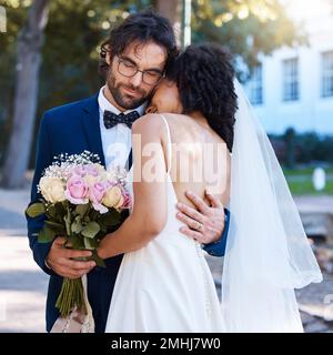 Hochzeit, Liebe und Paar, die sich im Freien umarmen, um eine Hochzeitsfeier für Braut und Bräutigam zu feiern. Verheirateter, gemischter Mann und Frau bei der Verlobung Stockfoto