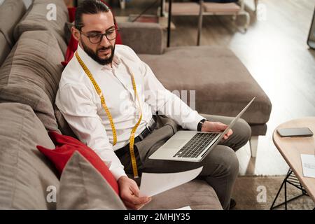Modedesigner, der sich Skizzen in seinem Atelier ansieht Stockfoto