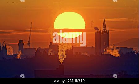 Glasgow, Schottland, Vereinigtes Königreich 27.t. Januar 2023. UK Weather: Cold Red Dawn sah den Sonnenaufgang über dem West End und den gotischen Turm der Universität Glasgow, als sich Wasserdampf und Rauch in der kalten Luft verfestigten. Credit Gerard Ferry/Alamy Live News Stockfoto