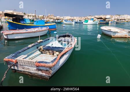 Kleine maltesische Fischerboote liegen an einem sonnigen Sommertag im Hafen von Marsaxlokk, Malta, vor Anker Stockfoto
