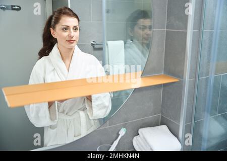 Eine schöne Frau steht vor einem Spiegel Stockfoto