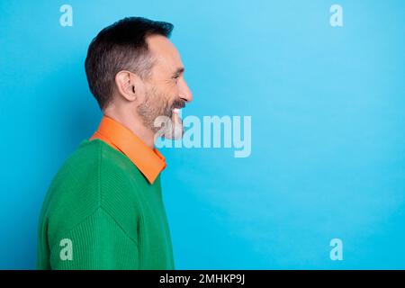 Seitenprofilfoto eines zufriedenen älteren grauen Bartmanns nach dem Friseur, der lächelnd aussieht, leerer Raum, neuer Werbespot isoliert auf blauem Hintergrund Stockfoto