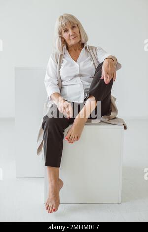 Studioporträt einer grauhaarigen Seniorin. Modefotografie im Studio. Wahrscheinlich ein älteres weibliches Porträt. Stockfoto