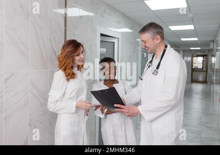 Eine Gruppe von Austauschärzten diskutiert die Diagnose im Krankenhauskorridor Stockfoto