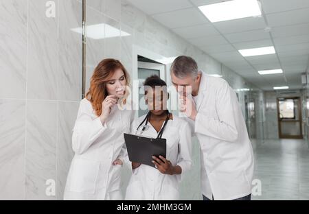 Eine Gruppe von Austauschärzten diskutiert die Diagnose im Krankenhauskorridor Stockfoto