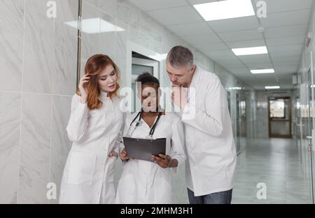 Eine Gruppe von Austauschärzten diskutiert die Diagnose im Krankenhauskorridor Stockfoto