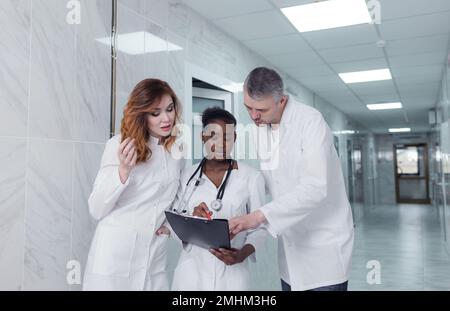 Eine Gruppe von Austauschärzten diskutiert die Diagnose im Krankenhauskorridor Stockfoto