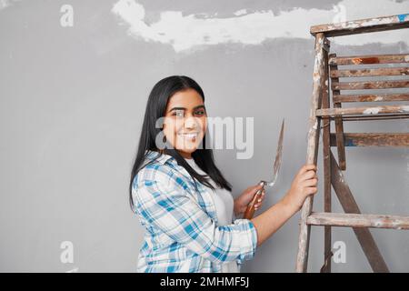 Junge Indianerin Pflaster über Risse im Heimwerkerprojekt Stockfoto