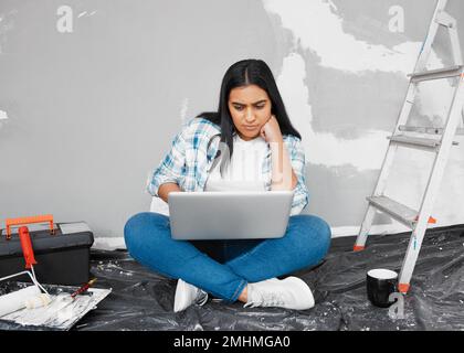 Eine junge Frau, die sich für Heimwerkerideen interessiert, verwendet Anleitungen bei der Renovierung Stockfoto
