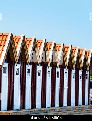 Skandinavische Architektur mit einer Reihe roter Sommerhäuser in Fotö hamn. Schwedische Gebäude mit typischen Sommerhäusern, Sommarstuga in Serie. Fotohafen Stockfoto