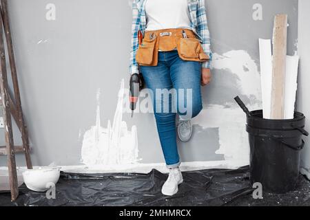Gekürzte Aufnahme einer jungen Frau, die Heimwerker macht und sich an die Wand lehnt, wird renoviert Stockfoto