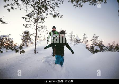 Zwei Freunde, die zusammen in der Winterlandschaft spazieren Stockfoto