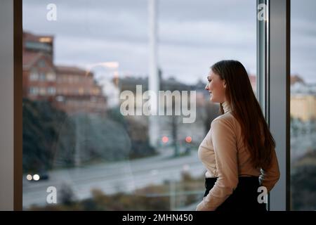 Junge Geschäftsfrau Blick durch Fenster Stockfoto