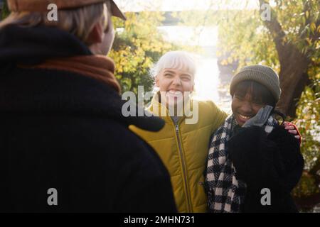 Fröhliche junge Frauen, die draußen reden Stockfoto