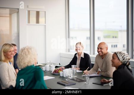 Lächelnde Leute bei einem Geschäftstreffen Stockfoto