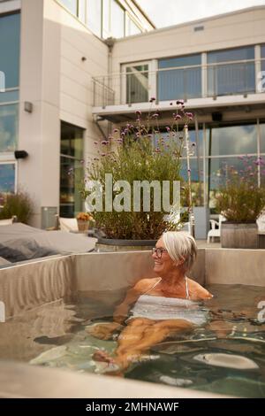 Seniorin, die sich im Whirlpool entspannt Stockfoto
